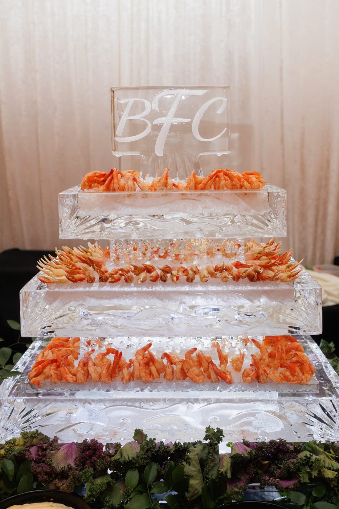 A tiered ice sculpture monogrammed BFC, layered with chilled shrimp and crab claws
